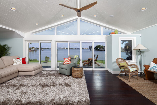 Modern coastal living room with expansive water views through bright white Hurricane Windows in Pinellas County, FL.