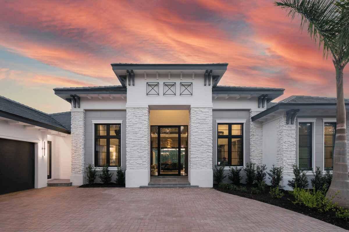 Stylish Florida house entrance with a brick driveway and durable Hurricane Windows in Pinellas County, FL.